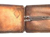 a small metal box with a pair of scissors inside of it