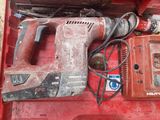 a red tool box with a hammer, drill, and other tools in it