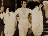 une photo en noir et blanc d'une femme portant une robe et un chapeau à plumes