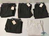 four pairs of men ' s dress pants with tags on them