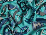 a close up of a green and blue scarf with a geometric design