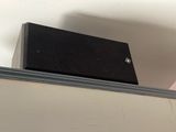 a small black box sitting on top of a shelf