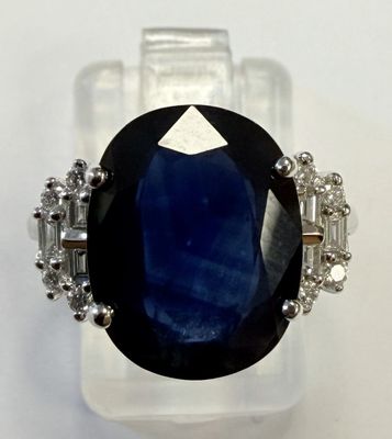 gros plan d'une bague avec une pierre bleue entourée de diamants