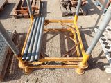 many pipes that are sitting on a cart in the dirt
