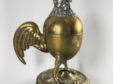 an image of a gold colored rooster figurine on a stand