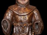 statue of a man in a monk ' s robes holding a book