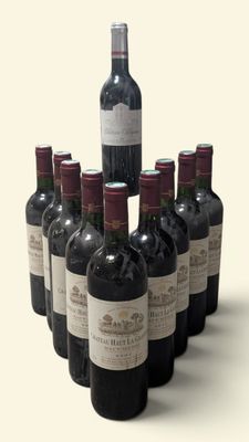 Des bouteilles de vin rouge sont disposées en pyramide sur une surface blanche