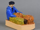 a figurine of a man sitting on a bed with a dog