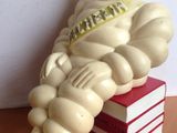 a statue of a man sitting on top of a stack of books