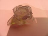 une fleur en verre posée sur une table, sur laquelle se projette une ombre
