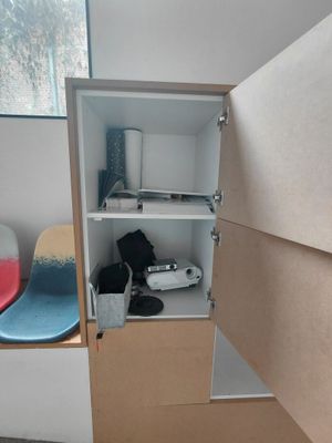une armoire dont la porte est ouverte et dans laquelle se trouve une paire de chaussures