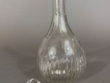 a clear glass bottle with a stopper next to it