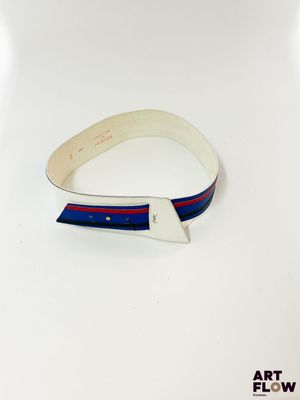 un gros plan sur une ceinture blanche ornée d'une bande bleue et rouge