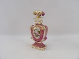 a pink and gold vase with a flower on it