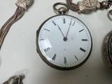 a silver pocket watch with a chain around it