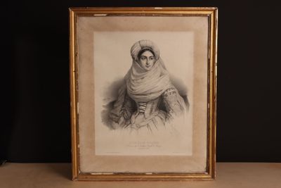 une vieille photo d'une femme portant un voile sur la tête, dans un cadre doré