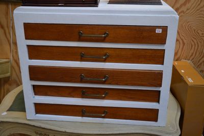 une commode blanche et marron posée sur une chaise