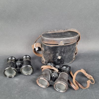 an old pair of binoculars sitting on top of a table next to a pair of glasses