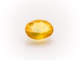 a yellow sapphire stone on a white background