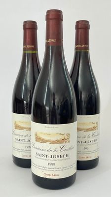 trois bouteilles de vin sont alignées sur une surface blanche