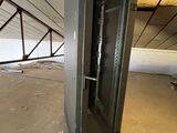 a metal cabinet in the middle of an unfinished room