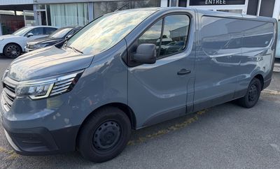 a grey van parked in front of a building in a parking lot
