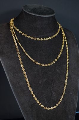 un collier à chaîne en or sur un mannequin, sur fond noir