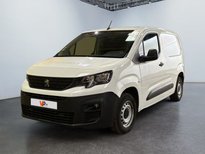 La petite camionnette blanche est garée dans une grande pièce