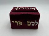 une image représentant une petite boîte rouge sur laquelle figure une inscription en hébreu