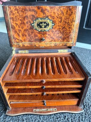 an old wooden box with six compartments sitting on a carpet