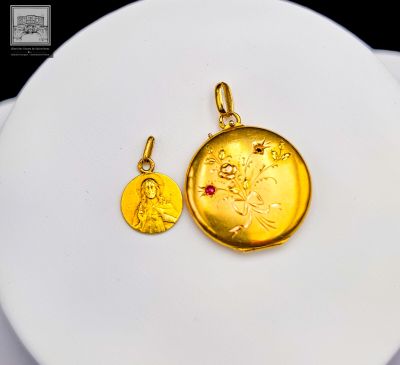 une pièce d'or et une pierre rouge sur une assiette blanche