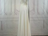bride dress on mannequin stand in front of white wall