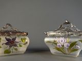deux vases décorés de fleurs, placés l'un à côté de l'autre