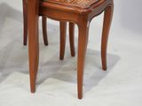 two wooden chairs with a woven seat on each of them
