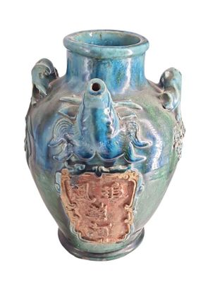 un vase bleu orné d'un oiseau sur fond blanc