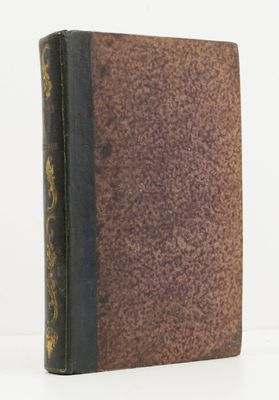 an old book sitting on top of a white table next to a white wall