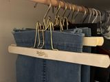 several pairs of jeans hanging on a rack in a closet