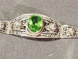silver bracelet with a green stone in the middle of it
