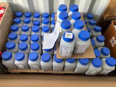 plusieurs bouteilles de lait posées sur une palette à côté d'un carton