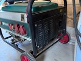 a green and black generator on a cart in a garage