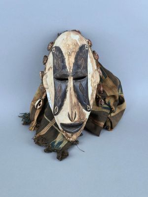 une image représentant un masque en bois peint en noir et blanc