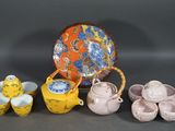 many different types of teapots and cups on the table