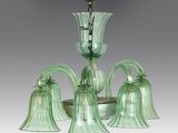 a green glass chandelier with five lights hanging from the ceiling