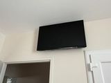 a flat screen tv mounted on the wall above a doorway