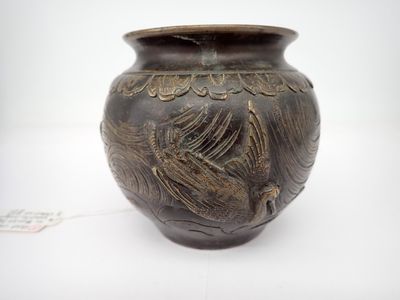un vase brun posé sur une surface blanche