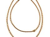 a close up of a gold chain necklace on a white background
