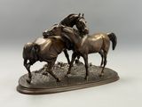 sculpture en bronze représentant deux chevaux galopant sur un sol rocheux