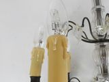 a chandelier with three candles and a candle holder on it