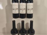 six bottles of wine sit on a shelf in front of a white wall