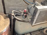 a small air compressor sitting in a dirty room